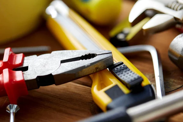 Zangen und verschiedene Arbeitswerkzeuge auf Holzbrettern — Stockfoto