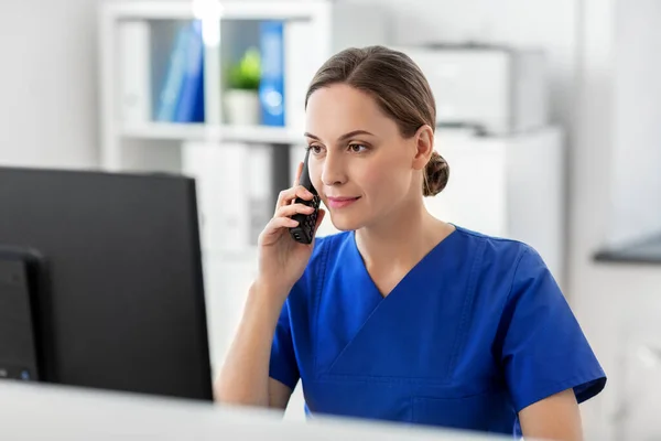 Médecin avec ordinateur appelant au téléphone à l'hôpital — Photo