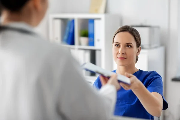 Arts en verpleegkundige met klembord in het ziekenhuis — Stockfoto