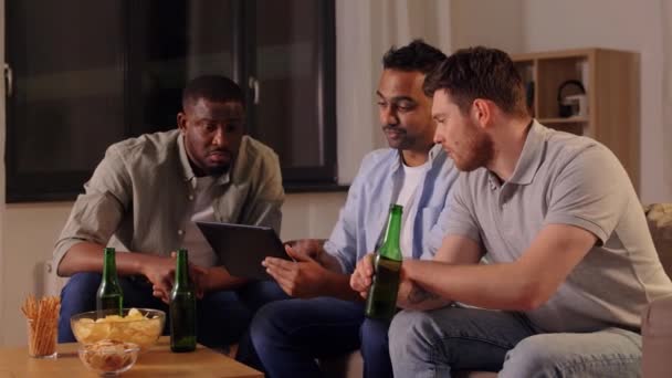 Mężczyzna przyjaciele z tablet picie piwa w domu — Wideo stockowe