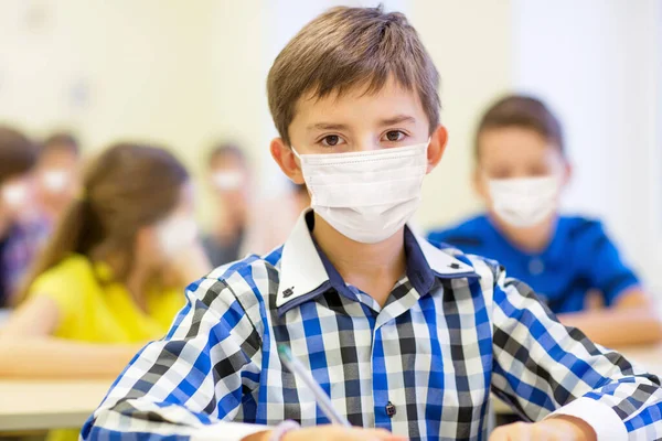 Estudante menino em máscara médica protetora na escola — Fotografia de Stock