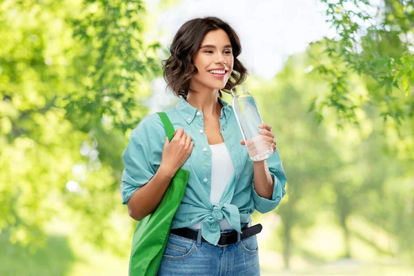 Mujer con bolsa para compras de alimentos y botella de vidrio — Foto de Stock