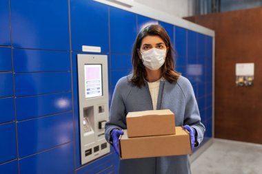 woman in mask with boxes at parcel machine clipart