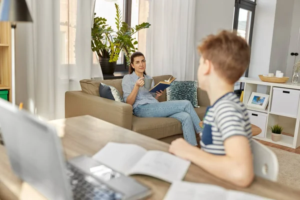 Matka s knihou mluvit se synem učení doma — Stock fotografie