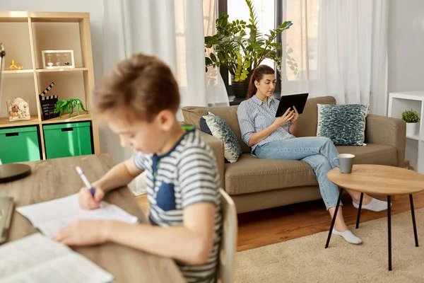 Mamma med surfplatta och son lärande hemma — Stockfoto