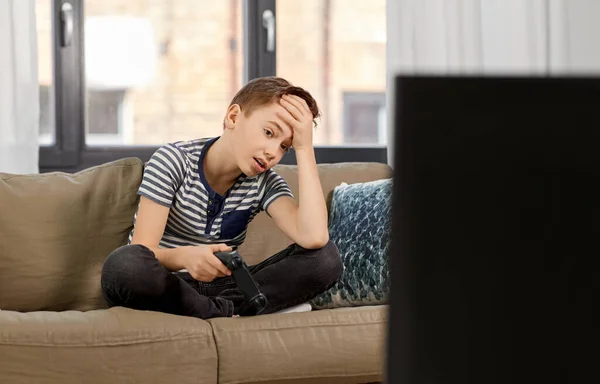 Triste chico con gamepad jugando videojuego en casa — Foto de Stock