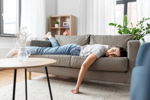 Mujer joven aburrida o perezosa acostada en el sofá en casa — Foto de Stock