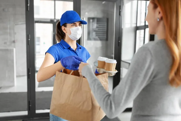 Consegna ragazza in maschera dando sacchetto di carta al cliente — Foto Stock