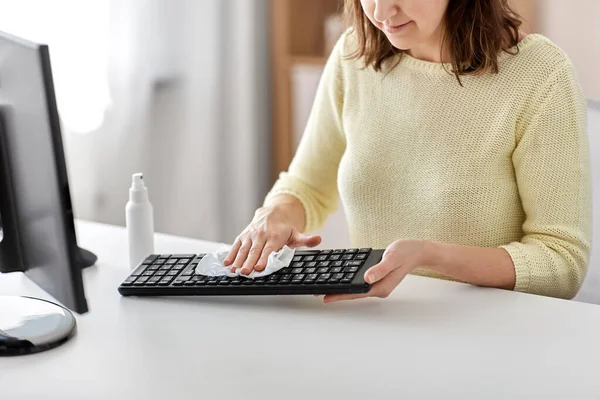 Close up of woman cleaning keyboard with sanitizer — Stock Photo, Image