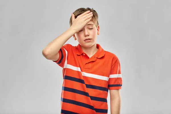 Chico en polo rojo camiseta con dolor de cabeza —  Fotos de Stock