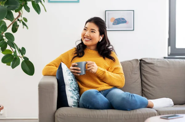 Mujer en auriculares escuchando música en casa — Foto de Stock