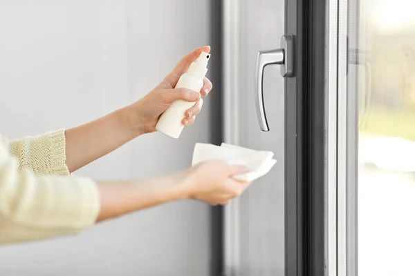 Kvinna rengöring fönster handtag med rengöringsmedel vävnad — Stockfoto