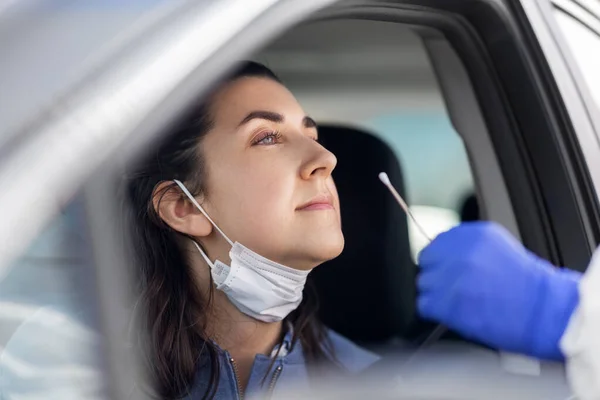 Hälso- och sjukvårdspersonal som gör coronavirus test i bilen — Stockfoto