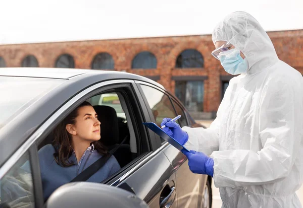 Trabajador sanitario con portapapeles y mujer en coche —  Fotos de Stock