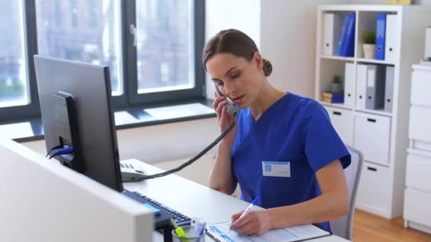 Doctor con computadora llamando por teléfono en el hospital — Vídeos de Stock