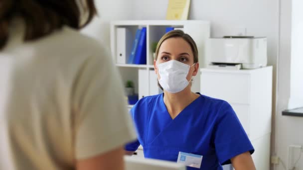 Kadın doktor hastanedeki hastaya maske teklif ediyor. — Stok video