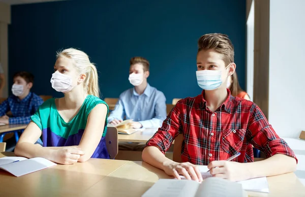 Grupo de estudiantes con máscaras en la clase escolar —  Fotos de Stock