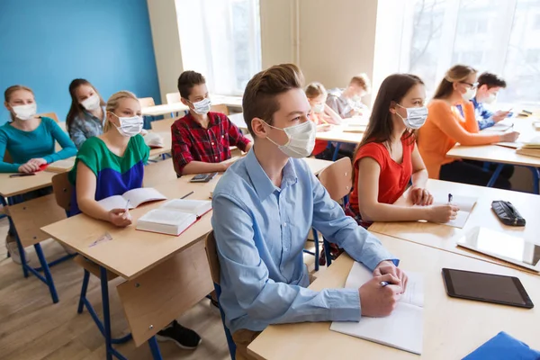 Skupina studentů v maskách na školní hodině — Stock fotografie