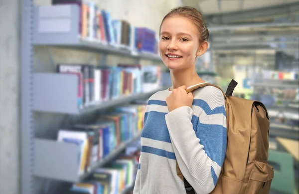 Tonårstjej med skolväska på biblioteket — Stockfoto