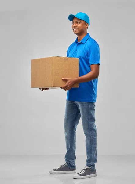 Hombre de reparto indio feliz con caja de paquete en azul — Foto de Stock