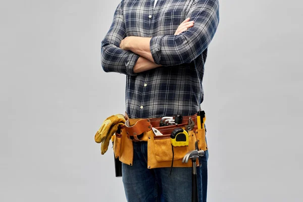 Мужчина работник или строитель с рабочими инструментами на поясе — стоковое фото