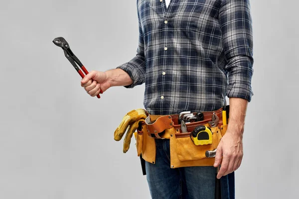 Trabajador o constructor con llave inglesa y herramientas en la correa — Foto de Stock