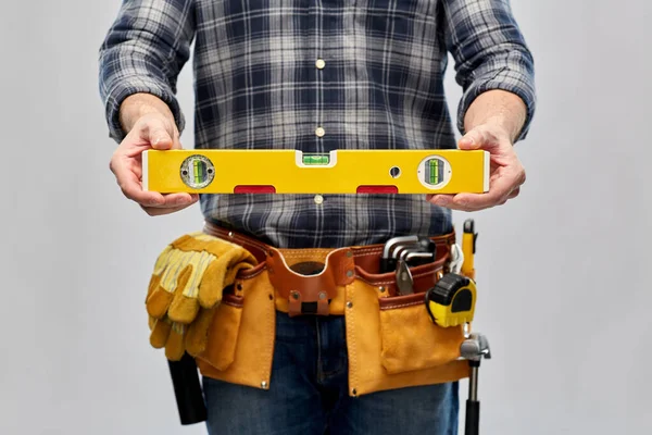 Męski budowniczy z poziomu i narzędzi roboczych na pasie — Zdjęcie stockowe