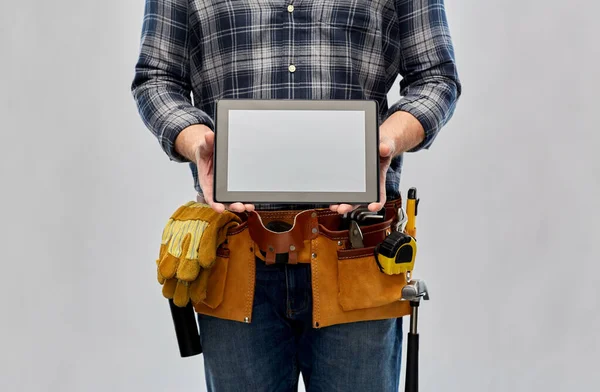 Male builder with working tools showing tablet pc — Stock Photo, Image