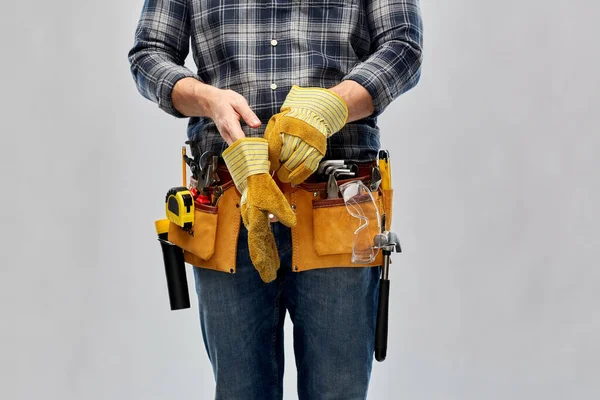 Οικοδόμος με εργαλεία εργασίας βάζοντας γάντια — Φωτογραφία Αρχείου