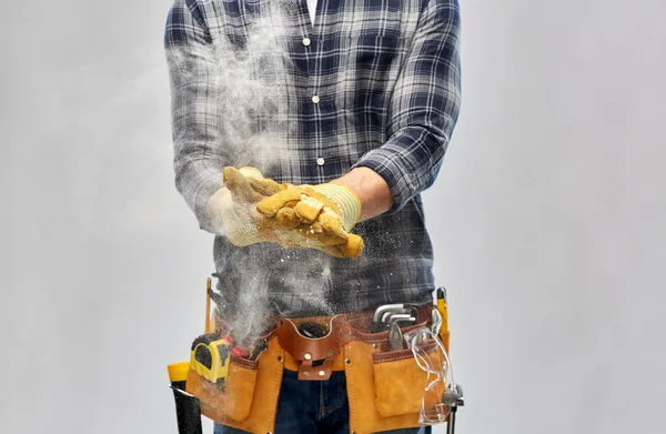 Construtor com ferramentas de trabalho e luvas usando talco — Fotografia de Stock