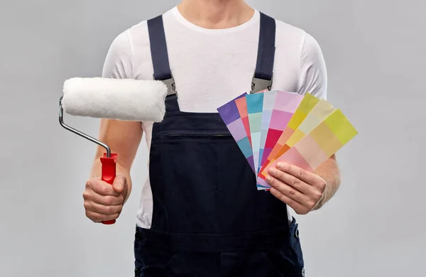 Close up of painter with roller and color charts — Stock Photo, Image