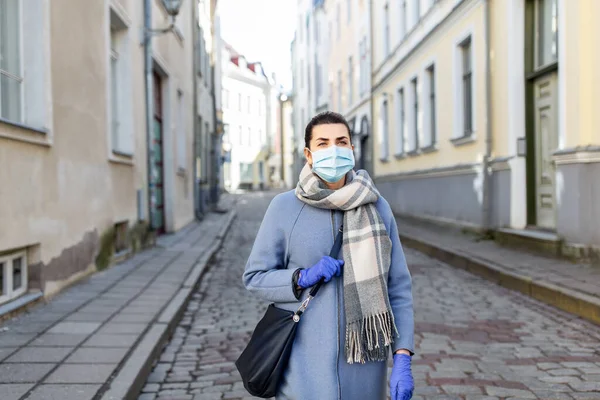 街には医療用マスクと手袋をした女性が — ストック写真