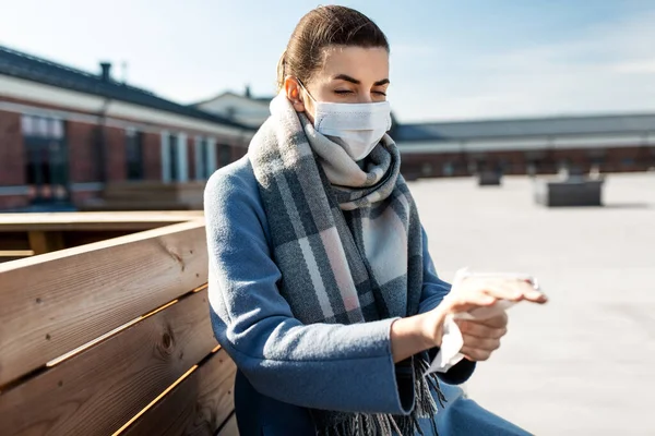 Femme dans le masque de nettoyage des mains avec lingette humide en ville — Photo