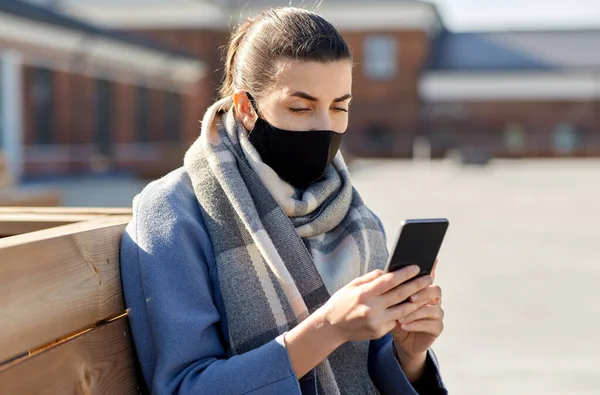Γυναίκα με μάσκα προσώπου με smartphone στην πόλη — Φωτογραφία Αρχείου