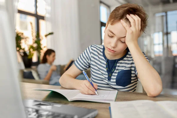 Junge mit Buch zu Hause ans Notizbuch — Stockfoto
