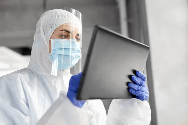 Médico em desgaste protetor com computador tablet — Fotografia de Stock