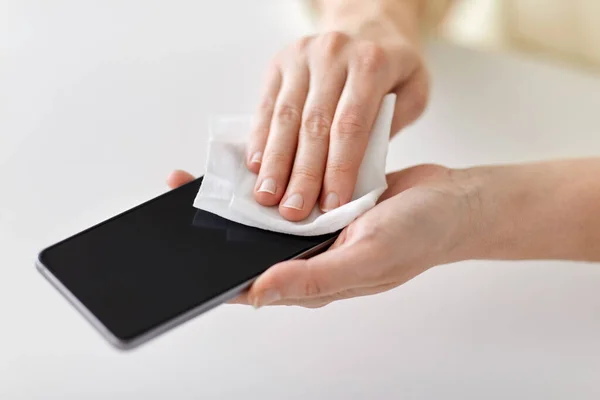 Закрытие рук для чистки смартфона с помощью ткани — стоковое фото