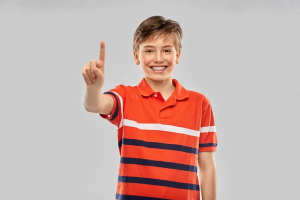 Porträtt av glad leende pojke som visar ett finger — Stockfoto