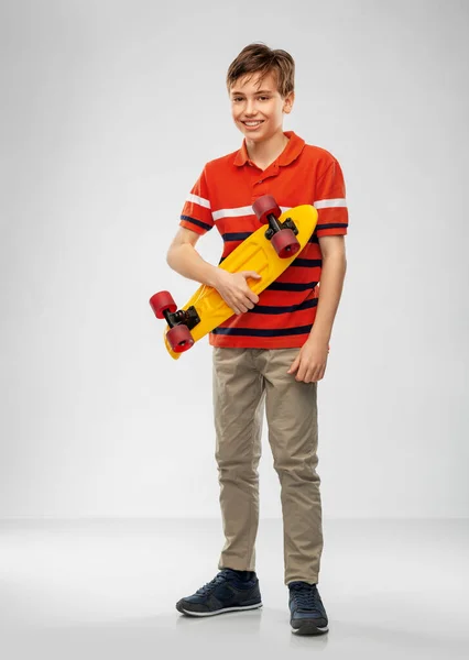 Lächelnder Junge mit kurzem Skateboard — Stockfoto