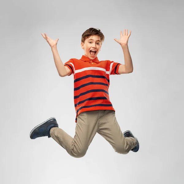 Szczęśliwy uśmiechnięty młody chłopiec skaczący w powietrzu — Zdjęcie stockowe