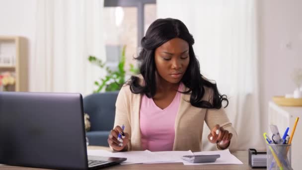 Mujer con calculadora y papeles trabajando en casa — Vídeos de Stock