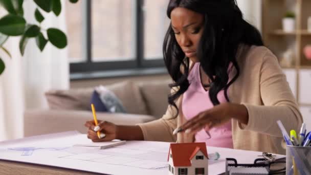 Female architect with house model and blueprint — Stock Video