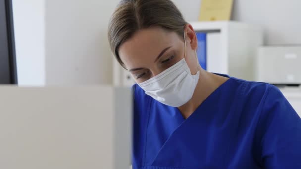 Läkare eller sjuksköterska i mask med urklipp på sjukhus — Stockvideo