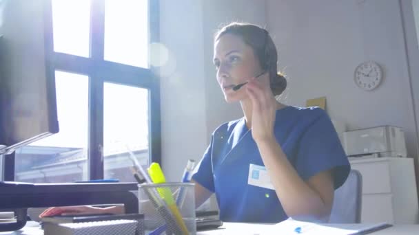 Médico con auriculares y ordenador en el hospital — Vídeos de Stock