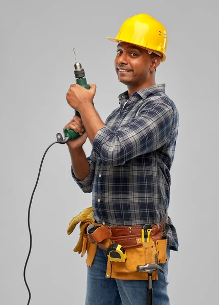 Construtor indiano feliz no capacete com broca elétrica — Fotografia de Stock