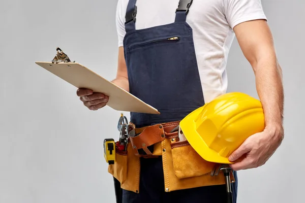 Мужчина-строитель с буфером обмена и рабочими инструментами — стоковое фото