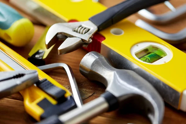 Diferentes ferramentas de trabalho em pranchas de madeira fundo — Fotografia de Stock