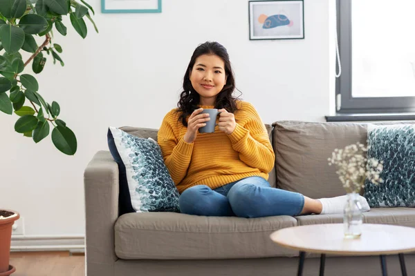 Sonriente asiático joven mujer bebiendo café en casa — Foto de Stock