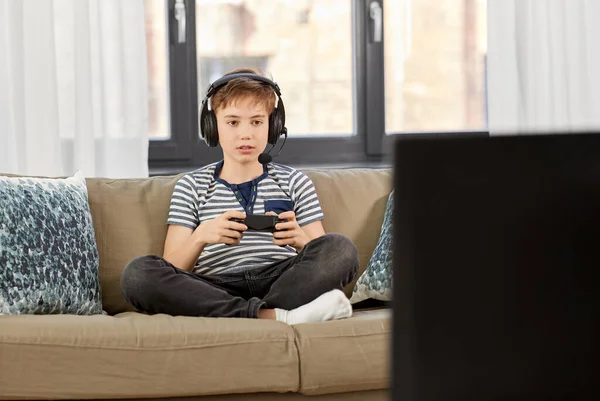 Chico con gamepad jugando videojuego en casa — Foto de Stock