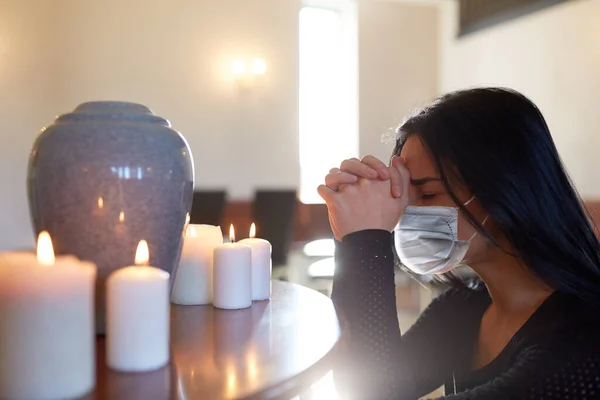 Sad woman in mask praying at funeral in church — Stock Photo, Image